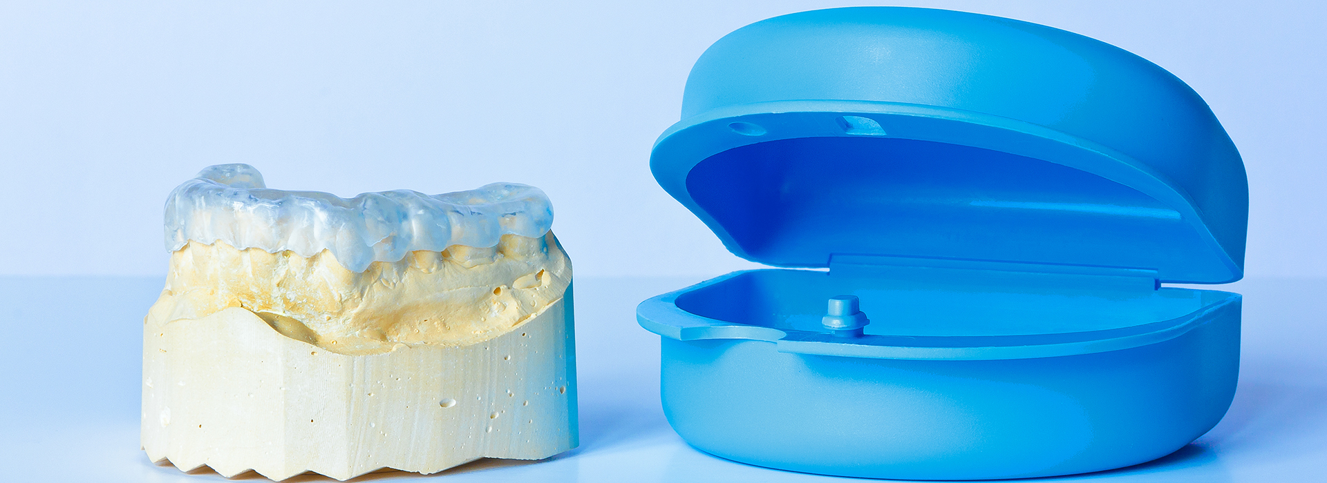 An image showcasing a dental implant and its corresponding blue model, likely for educational or sales purposes.