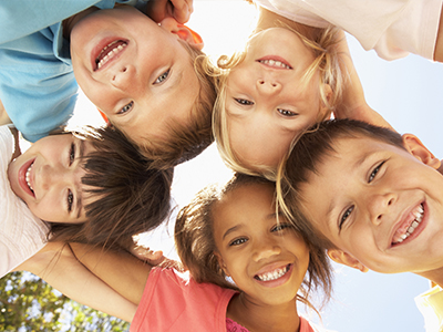 A group of children posing for a photo with smiles on their faces, displaying a sense of unity and joy.